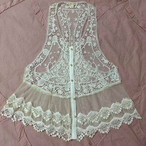 Cream color lace vest with pearl buttons and scalloped crochet look bottom.